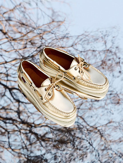 paire de mocassins docksides dorée posée sur un miroir